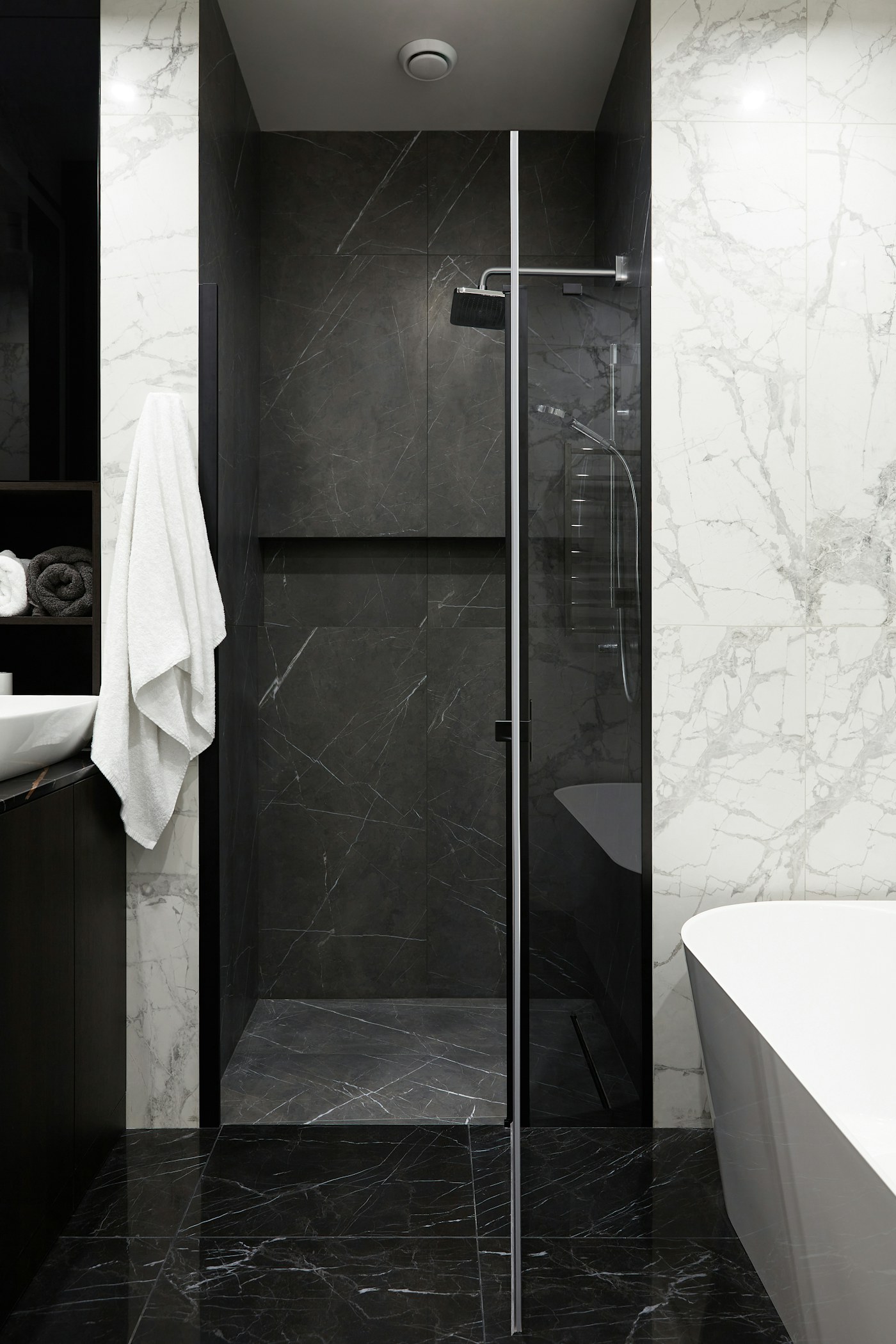 Siyah mermer duş alanı ve beyaz damarlı mermer duvar kaplamalı banyo